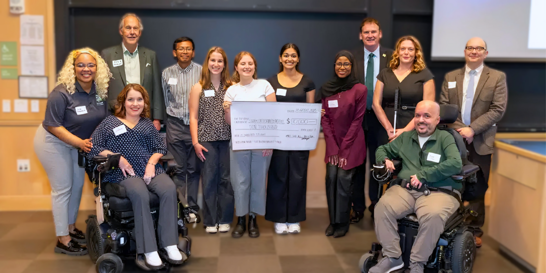 A group of WashU students and SDI leadership and staff smiling during the check presentation.