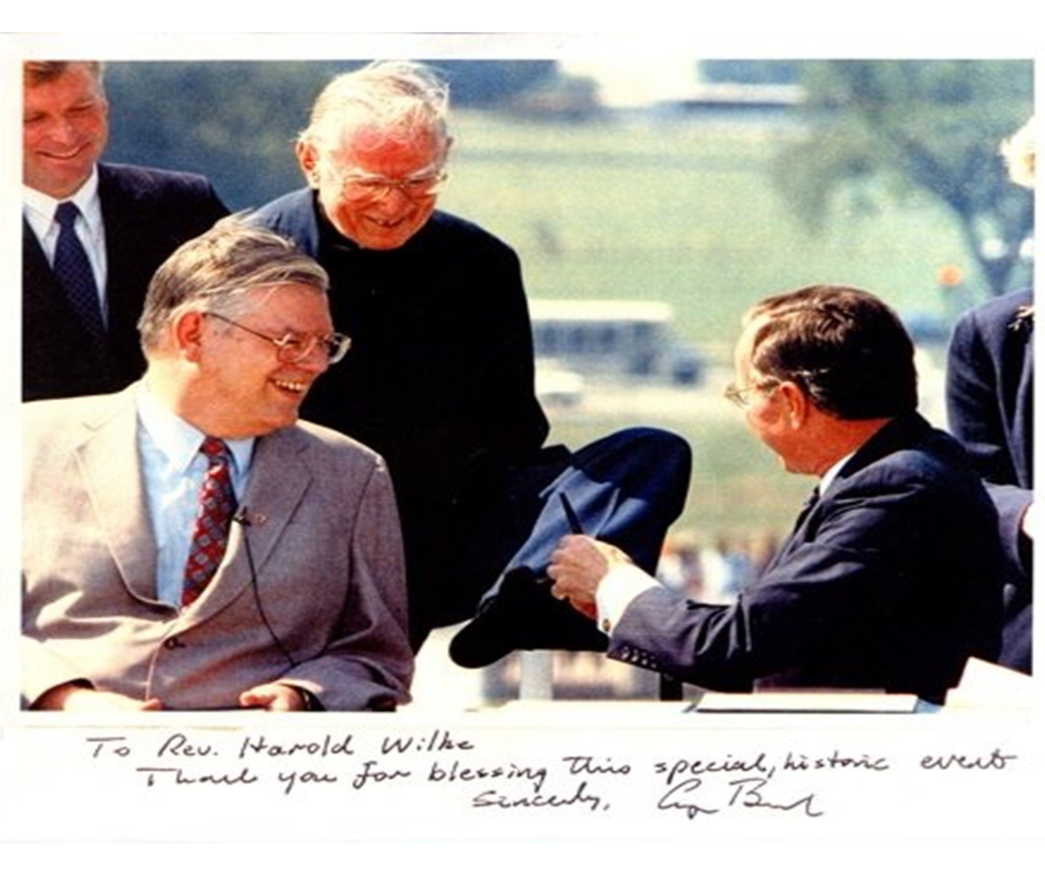 Rev. Wilke using his toes to accept a pen from President Bush at the ADA signing.