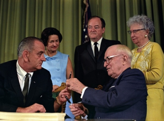 President Johnson handing President Truman the pen he used to sign Medicare into law.