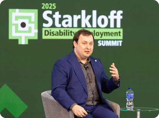 Daniel Van Sant delivering closing keynote while seated on stage.